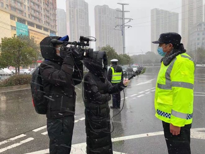 孝感市融媒體中心楊亞玲（風(fēng)雪中，采訪疫情期間重返一線的退休警察）_副本.jpg.jpg